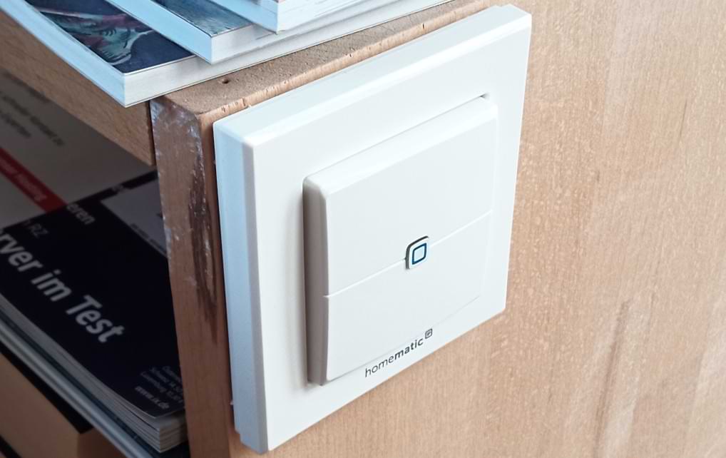 Homematic IP Wanttaster. Batteriebetrieben an Nachtkästchen montiert.
